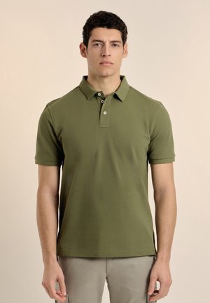 Polo de color verde oliva hecho de tela texturizada, con cuello, tapeta de tres botones y sutil bordado del logo en el pecho.
