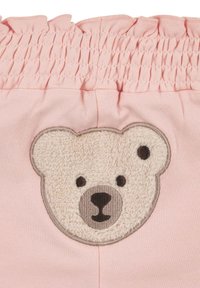 Shorts in cotone rosa con un volto di orso ricamato e testurizzato sul davanti, caratterizzati da un orso bianco in peluche con dettagli grigi intorno alle orecchie e al muso.
