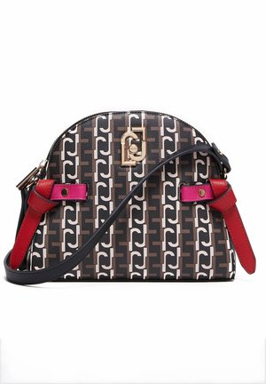 Sac bandoulière en forme de croissant avec un motif géométrique noir, marron et blanc, des accents en cuir rouge et rose, et des éléments en matériel doré.