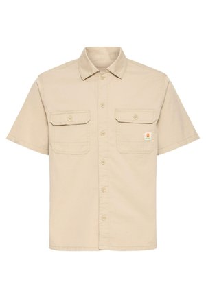 Beige kortærmet skjorte med knapper, to frontlommer med klap, krave og lille orange mærkat på højre lomme.