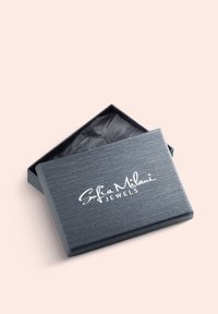Grå rektangulær smykkeboks med en tekstureret overflade, featuring en sort indvendig og hvid prægede logo "Sofia Milani JEWELS" på låget.