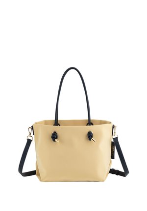 Sac fourre-tout étanche jaune avec des poignées noires et une sangle amovible. Comprend des détails en or et une texture douce avec des accents noués.