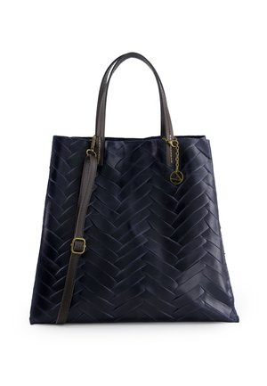 Granatowa pikowana torba na ramię z ciemnobrązowymi skórzanymi uchwytami i regulowanym paskiem na ramię, z małym złotym zawieszką na uchwycie.