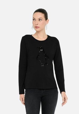 Zwarte langgeremde t-shirt met een pailletten ontwerp van een pinguïn in zilver en zwart in het midden, gemaakt van zacht materiaal met een ronde halslijn.