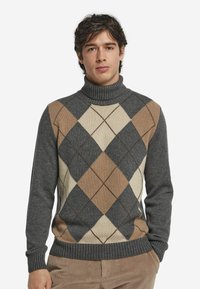 Grauer Rollkragenpullover mit einem Rautenmuster in Beige, Braun und Hellgrau. Stricktextur mit gerippten Bündchen und Saum.