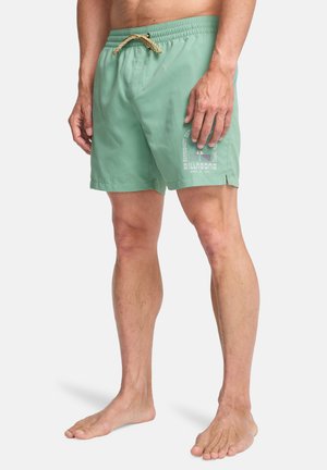 Lysegrønne badebukser med snøre i taljen, sideslids og printet logo. Fremstillet af hurtigtørrende materiale for komfort.