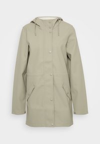 Chaqueta impermeable de color beige claro con capucha, botones a presión, dos bolsillos laterales y detalle de cordón; textura suave y diseño casual.