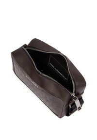 Barna bőr táska textúrázott mintával, ezüst cipzárral, kontrasztos belső térrel és állítható pánttal. A logó látható a belső részben.