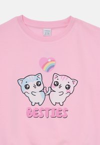 Felpa rosa con grafica di gatti. Presenta due gatti dei cartoni animati in blu e rosa che si tengono per le zampe, con un cuore e un arcobaleno sopra, e il testo "BESTIES".