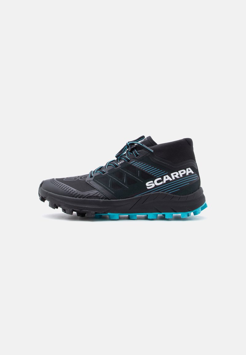 Chaussure de randonnée haute noire et bleue avec semelle texturée, lacets noirs et logo "SCARPA" sur le côté.