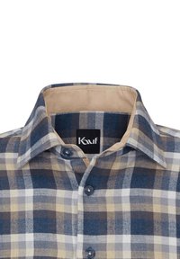Camicia a quadri nei toni del blu, marrone e beige; presenta un colletto button-down, bottoni scuri e una texture di tessuto morbida. Etichetta del marchio visibile.