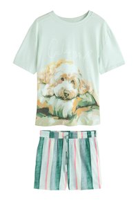 Conjunto de pijama de color verde claro que presenta una camiseta de manga corta con una ilustración de un perro y el texto "Cockapooped", acompañado de pantalones cortos a rayas en tonos verdes y pasteles.