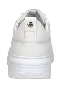 Weißer Sneaker mit einem glatten Lederobermaterial, gepolstertem Kragen und einem einzelnen Metallelement an der Ferse. Dicke, strukturierte Gummisohle.