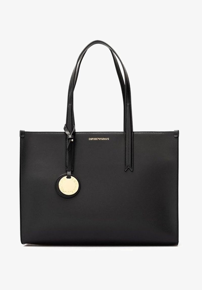 Sac fourre-tout en cuir noir avec doubles poignées, plaque logo dorée et design minimaliste. Présente une texture lisse et une forme rectangulaire.