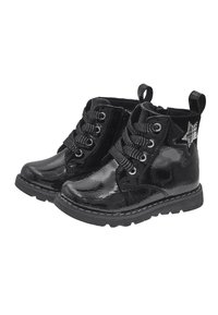 Botas de charol negro con un acabado brillante, diseño de cordones, cordones negros texturizados y un acento de estrella plateada en el lateral. Suela de goma.