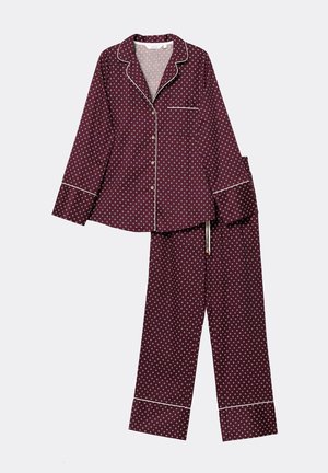 Bordowy zestaw piżamowy wykonany z miękkiego materiału, ozdobiony białymi kropkami, kontrastowymi lamówkami oraz koszulą z guzikami i kieszonką oraz spodniami z troczkami.