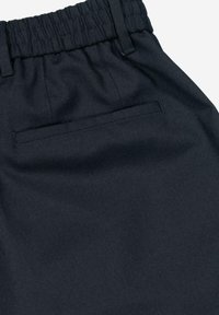 Dark navy pants featuring a soft, textured fabric with a gathered elastic waistband and a discreet rear pocket.
