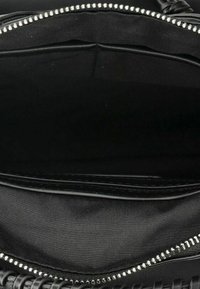 Interno della borsa nera con una fodera in tessuto liscio. Presenta una tasca con zip con hardware in metallo di tonalità argento lungo il bordo.