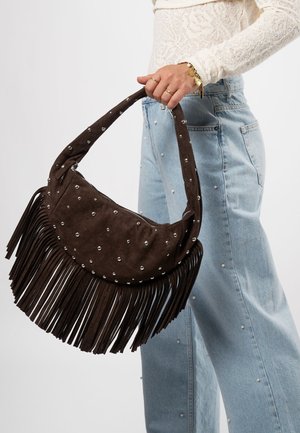 Bruine suède handtas met franjes en zilveren studs, voorzien van een gebogen handvat en ritssluiting. Draag het met lichtblauwe jeans met parelaccenten.
