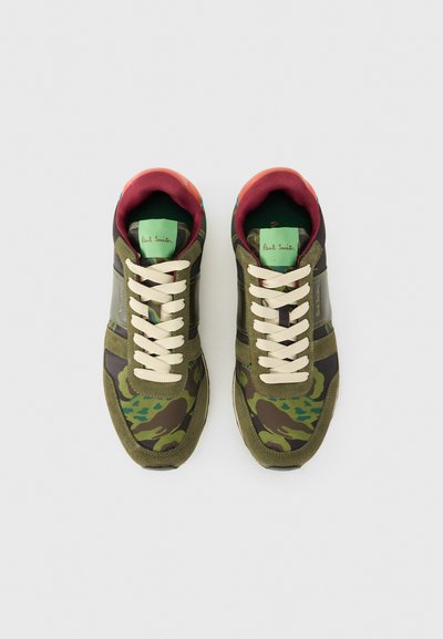 Olivgrüne Sneakers mit Camouflage-Muster, aus Wildleder und Nylon, mit cremefarbenen Schnürsenkeln, kastanienbraunen Akzenten und Logo auf der Zunge. Klassisches sportliches Design.