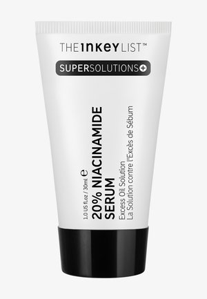 Tubo bianco con accenti neri, etichettato "Siero al 20% di Niacinamide." Presenta una texture morbida e opaca, una punta appuntita e una base nera.