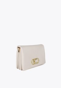 Borsa beige chiaro con una chiusura a logo dorato, parzialmente aperta, che mette in mostra un design elegante e minimalista. Un accessorio moderno per vari outfit.