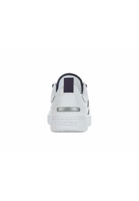 White athletic sneaker with a smooth leather upper, padded heel, navy accents, and textured rubber sole. Features a silver detail on the heel.