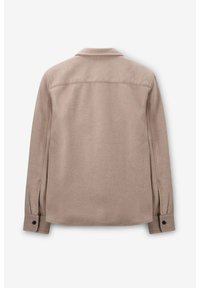 Chemise colonnée en tissu beige clair, présentant une texture lisse, des manches longues avec des poignets à boutons, et un design épuré et minimaliste.