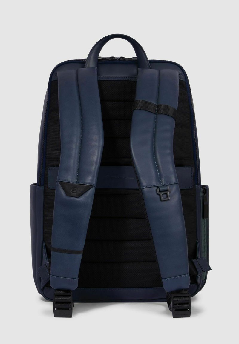 Zaino in pelle blu navy con schiena in rete imbottita, spallacci regolabili e tasca laterale. Presenta una maniglia superiore e una chiusura con fibbia sicura.