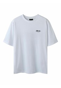 Hvid bomulds T-shirt med rund halsudskæring og korte ærmer. Har en lille sort tekstgrafik på venstre brystområde. Glat tekstur.