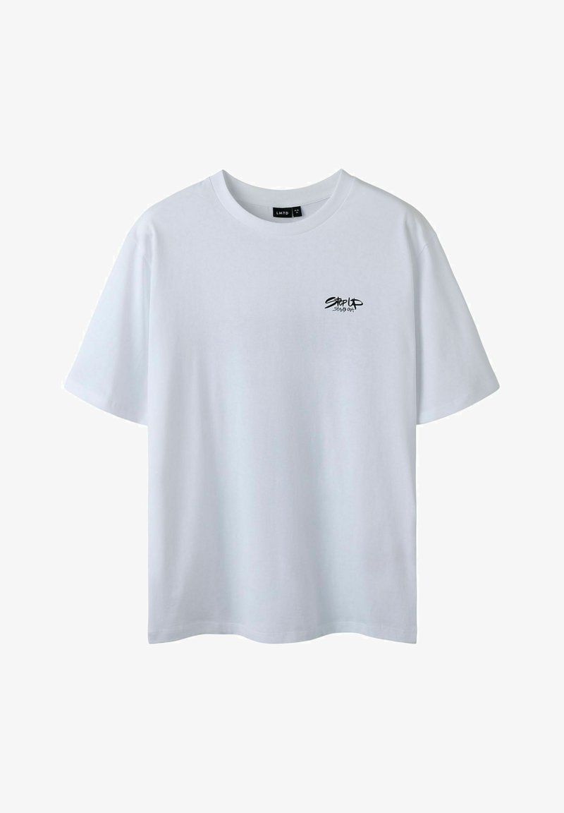 Camiseta de algodón blanca con cuello redondo y mangas cortas. Presenta un pequeño gráfico de texto negro en la zona del pecho izquierdo. Textura suave.