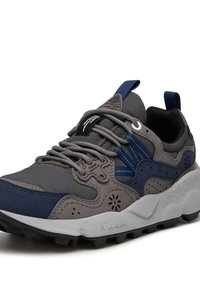 Scarpe da corsa grigie e blu scuro con tomaia texturizzata, accenti in mesh, suola robusta e perforazioni decorative. Presentano lacci a contrasto e una linguetta di aiuto.