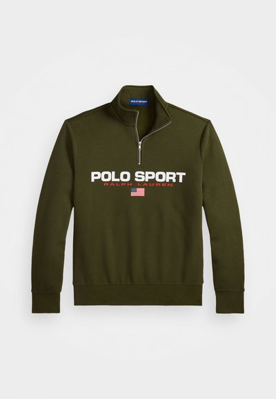 Olivnozeleni pulover s četrt zadrgo, ki vsebuje logo "POLO SPORT" v beli in rdeči barvi, z ameriško zastavo kot dodatkom spodaj. Material iz mešane bombažne tkanine.