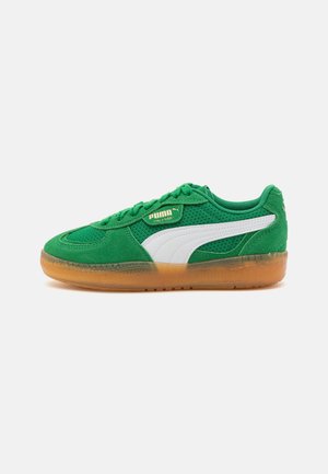 Green suede and mesh Puma sneaker with white stripe and translucent gum sole, viewed from the outer side.