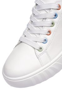 Bílá teniska s tlustými bílými tkaničkami prostrčenými barevnými očky v oranžové, modré a zelené barvě na bílé podrážce.