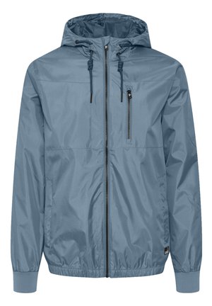 Hele sinine tuulejope kapuutsiga. Valmistatud kergest, veekindlast materjalist. Omab lukuga taskut ja elastseid mansette.