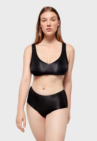 Zwart lingerieset met een eenvoudig, glad ontwerp, inclusief een bh met V-hals en high-waisted ondergoed. Gemaakt van zacht, rekbaar materiaal.