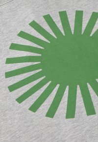 Motif en rayons verts en forme d'étoile avec des rayons triangulaires allongés sur un fond de tissu texturé gris clair.