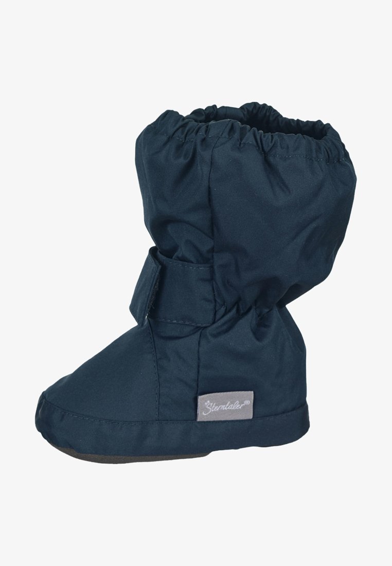 Dunkelblaue, wasserdichte Stiefel mit elastischem oberen Rand, verstellbarem Riemen und weicher Innenauskleidung. Flache, strukturierte Sohle für besseren Halt. Branding an der Seite.