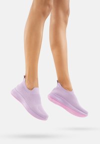 Lila gestrickte Sportschuhe mit einem strukturierten Obermaterial, Slip-On-Design und einer durchsichtigen rosa Gummisohle, die in der Luft präsentiert werden.