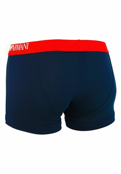 Boxer-briefs bleu marine avec une ceinture élastique rouge portant le logo "ARMANI" affiché en évidence sur le devant. Texture de tissu lisse.
