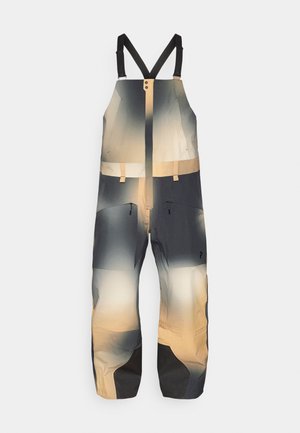 Pantalons de style bib d'extérieur avec des bretelles noires ajustables, couleur beige-gris dégradé, fermeture éclair à l'avant et poches sur la cuisse zippées.