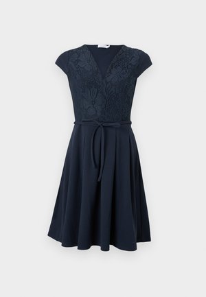 Mørkeblå kortærmet kjole med blomstret blonderpåklædning, V-udskæring, bindebånd i taljen og skørt med vidde til knæene.