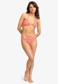 Červený kvetinový bikini s trojuholníkovým vrškom s nastaviteľnými popruhmi a zodpovedajúcimi nízkymi spodkami, vyrobené z ľahkej a elastickej tkaniny.