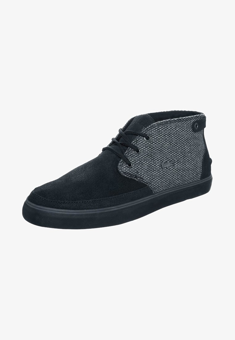 Chukka en suède noir et tissu texturé gris avec un bout arrondi, fermeture à lacets noire et semelle en caoutchouc noire. Détail du logo sur le côté.