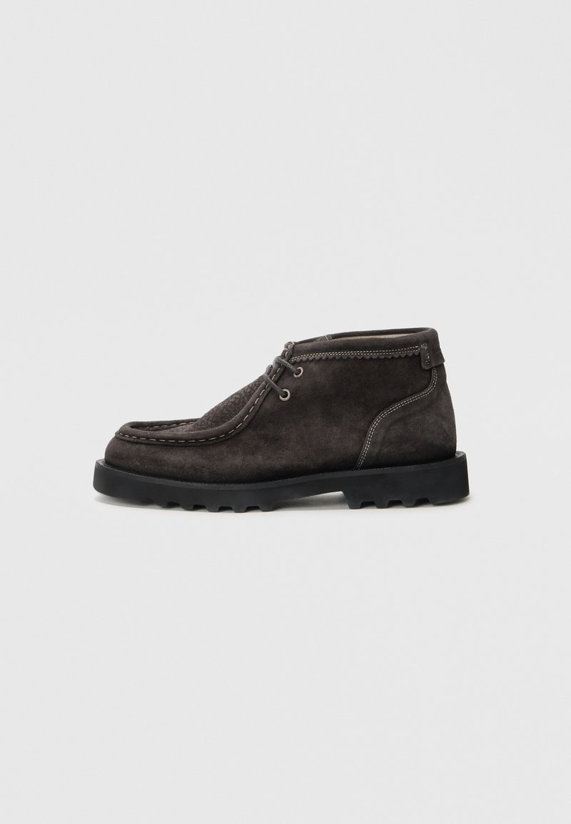 Dark grey suede ankle boots with a textured toe, lacing detail, and contrasting stitching. Features a rugged black rubber sole.