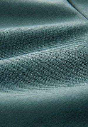 Tissu doux et texturé dans une couleur teal atténuée, présentant une surface lisse avec une légère élasticité et un motif côtelé uniforme tout au long.