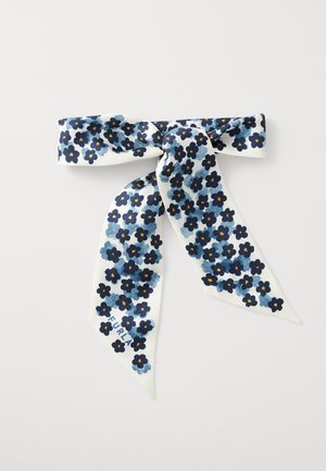 Floral scarf featuring a white background with navy blue flowers and orange centers, tied in a bow with two long, pointed ends.