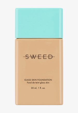 Rechteckige beige Foundation-Flasche mit türkisfarbenem Deckel, beschriftet mit "SWEED Glass Skin Foundation", enthält 30 ml (1 fl. oz.) Produkt.