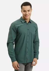 Zielona koszula w kratę z długimi rękawami, z klapami w kształcie spiczastym i czarnymi guzikami, wykonana z lekkiego materiału.